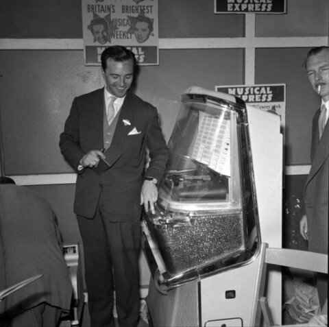 Man Beside Vintage Jukebox at Music Event