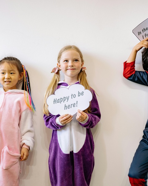 Children In Pajamas Holding Photo Booth Signs