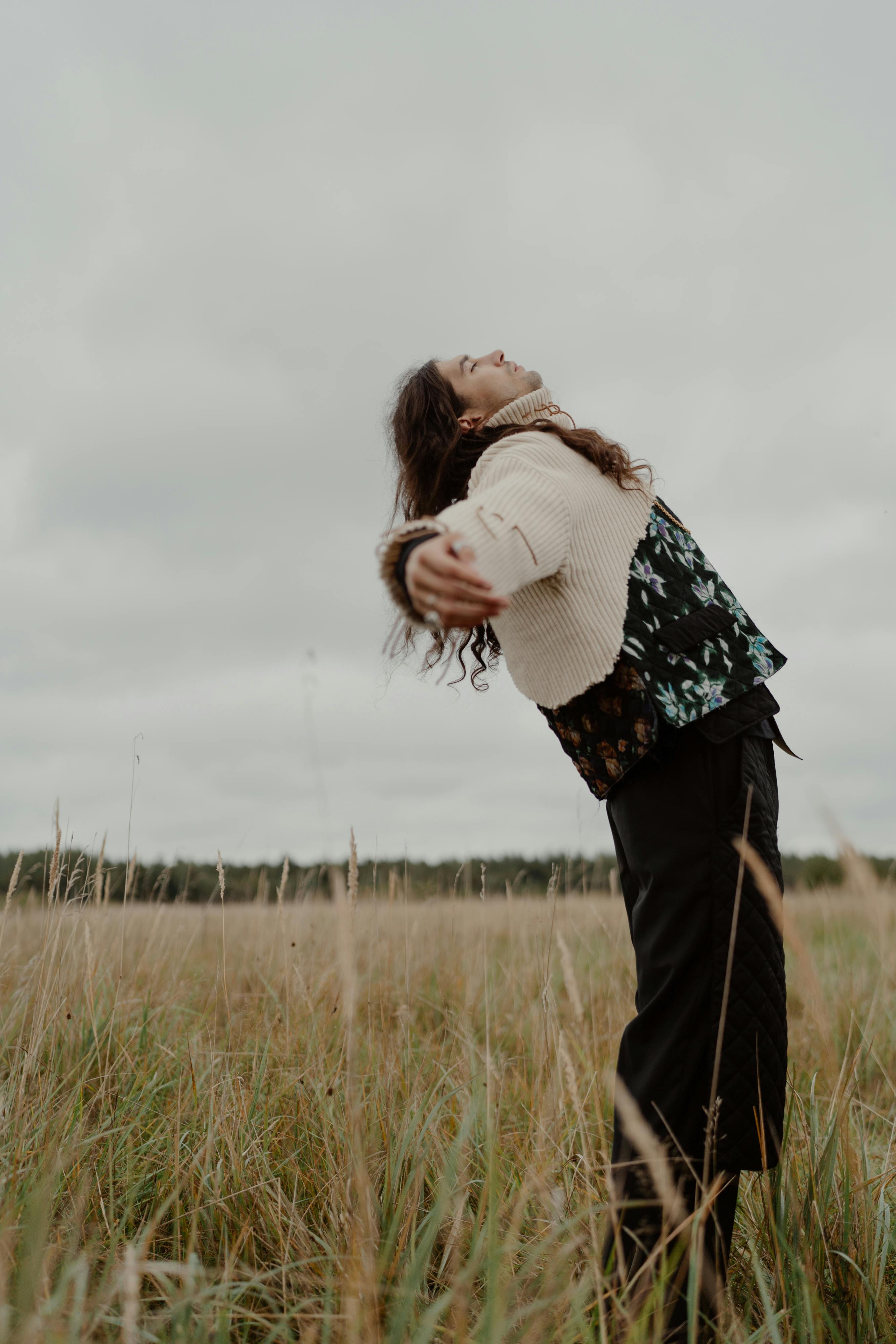 Person Stretching in Tall Grass Field