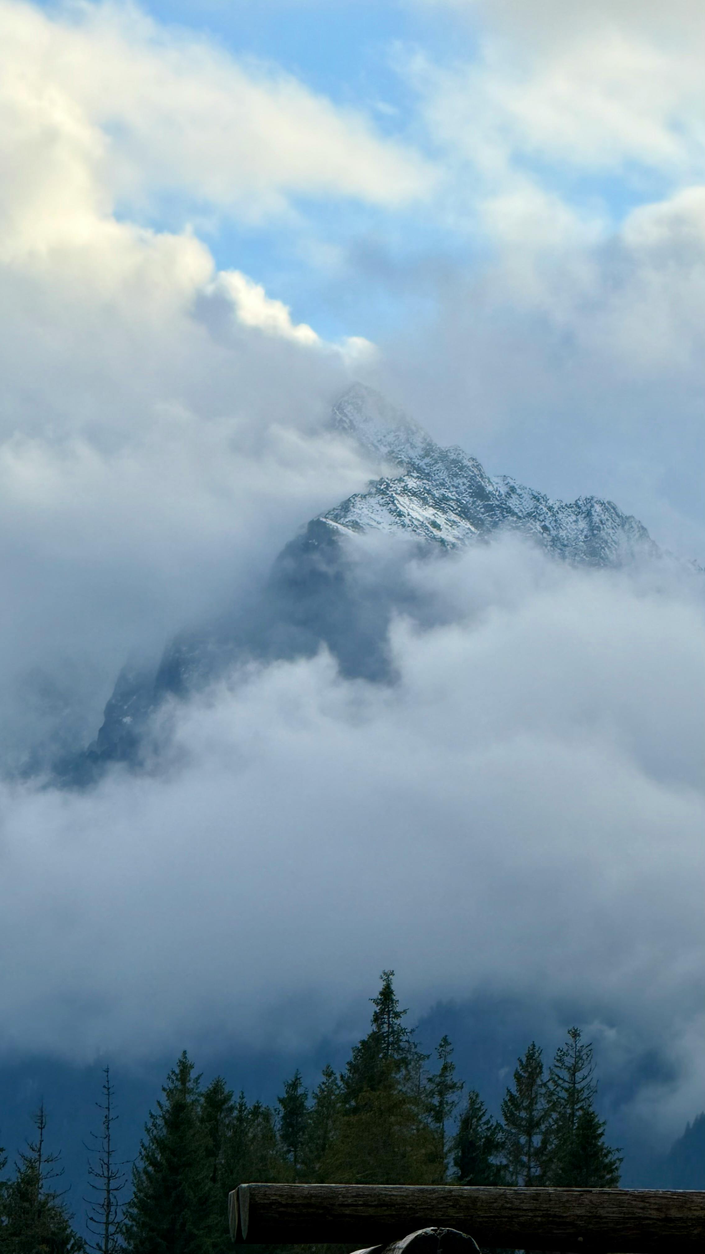 Snow-Capped Mountain Emerging from Clouds