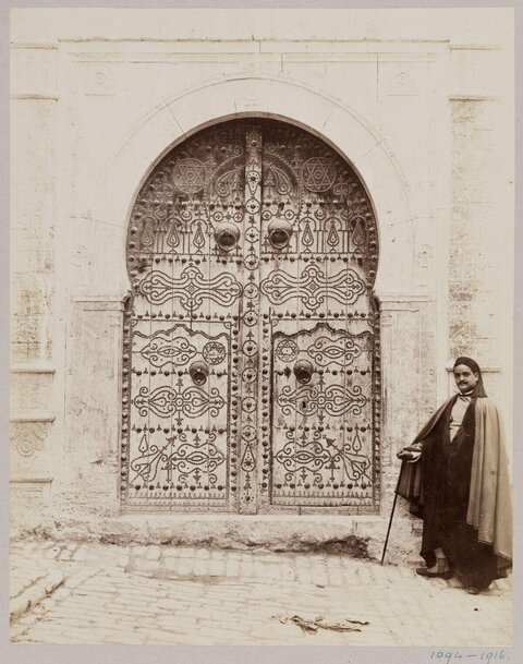 Vintage Ornate Arched Door with Standing Man