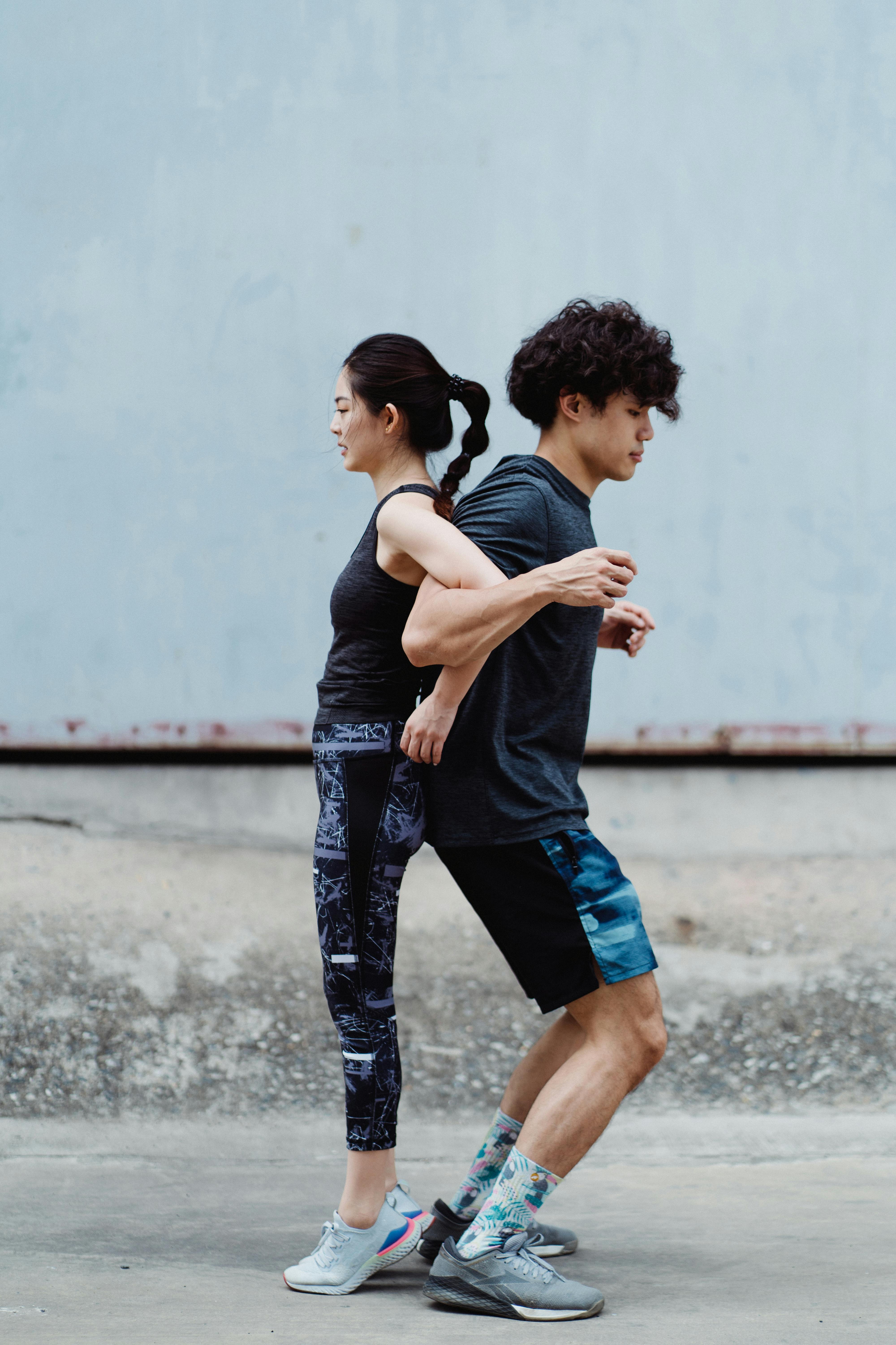Two Young Athletes Back-to-Back Running Pose
