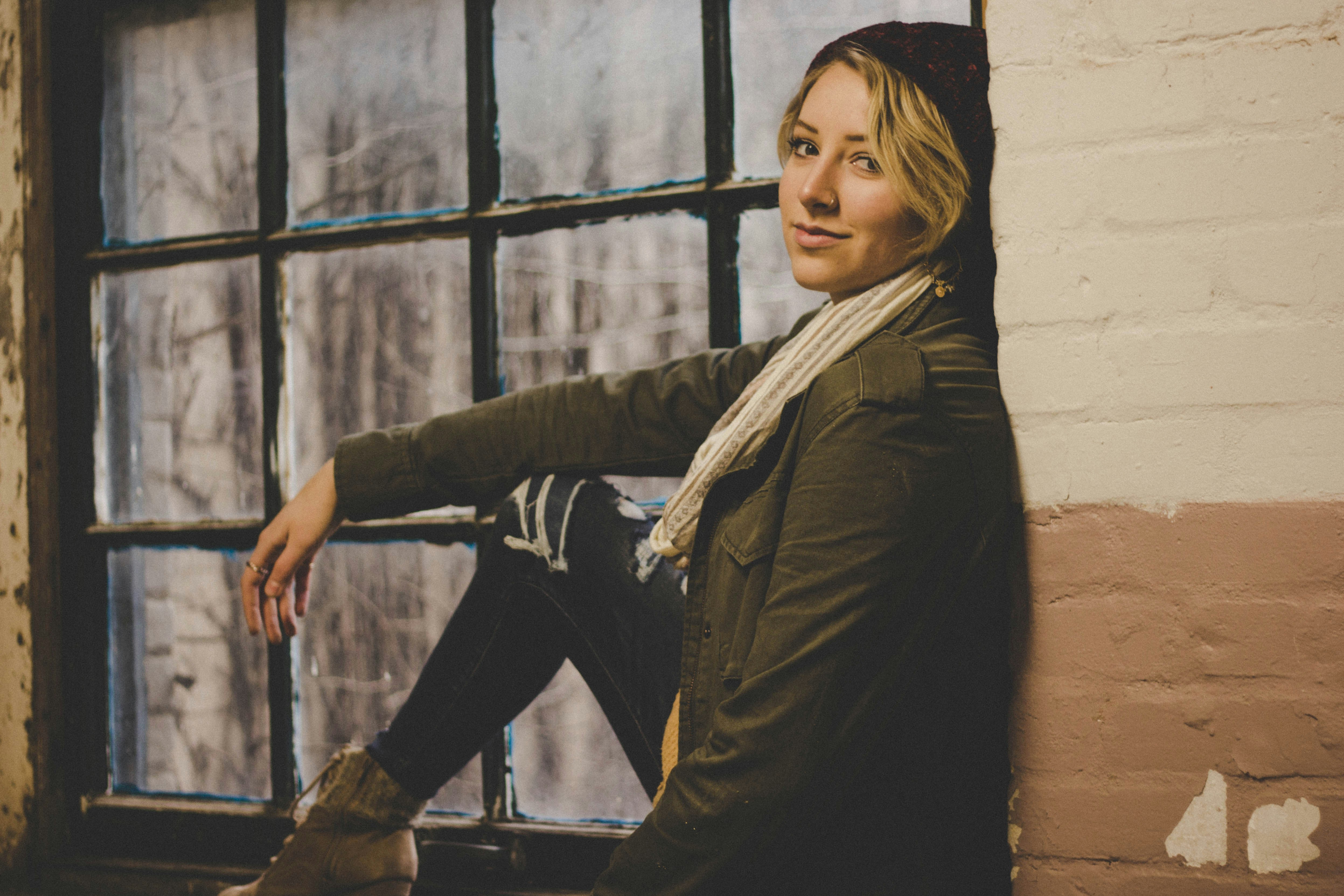 Woman Leaning Against Wall By Window