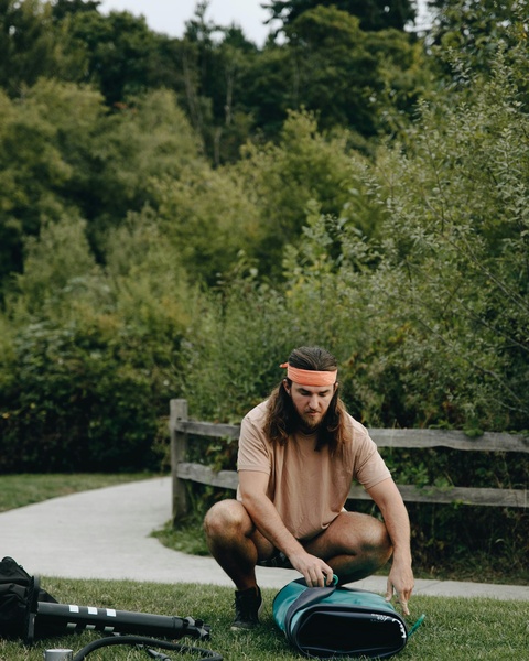 Man Preparing Paddleboard Equipment Outdoors