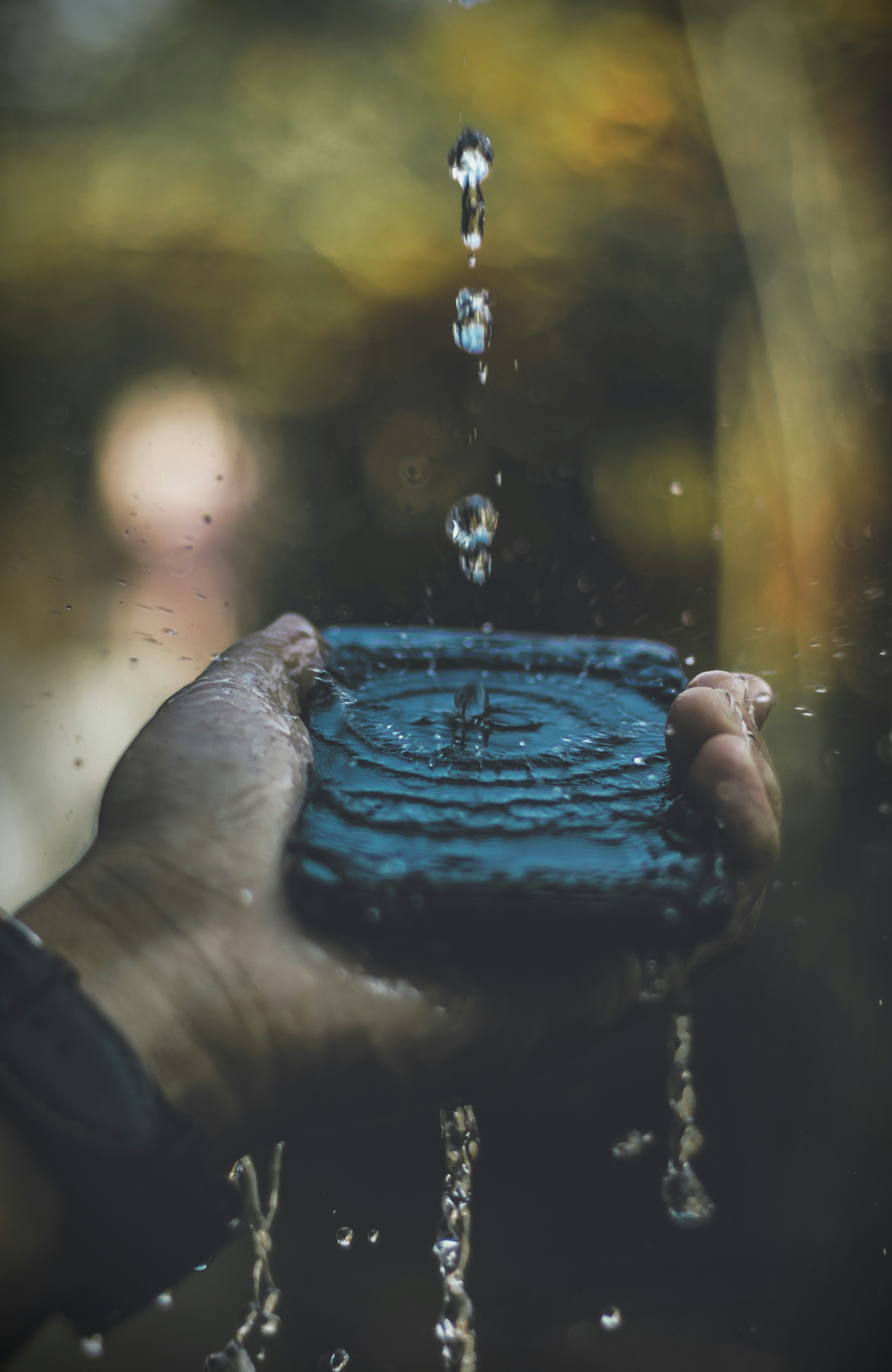 Water Drops Falling Into Hand-held Dish — Phone Wallpapers