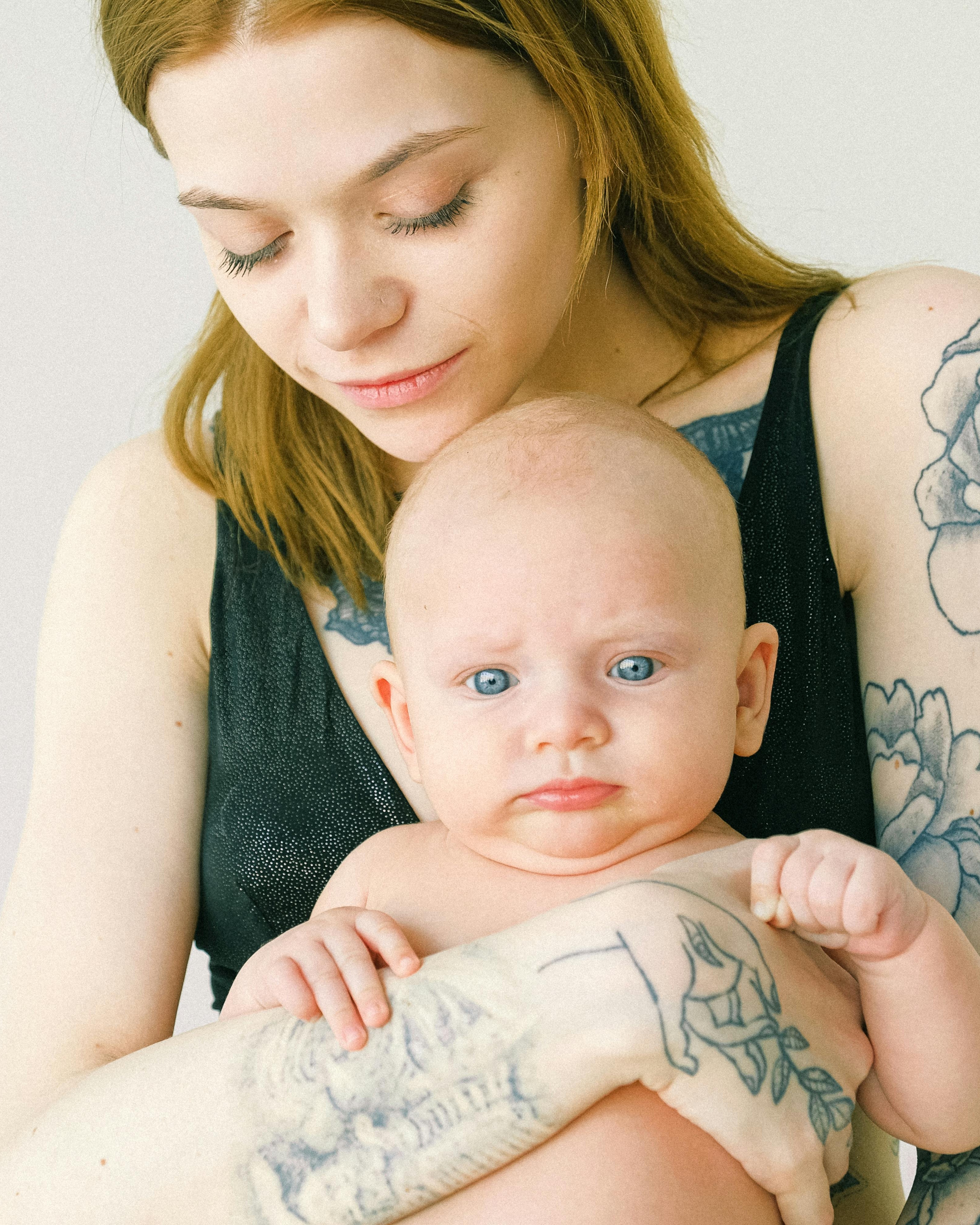 Tattooed Mother Holding Baby