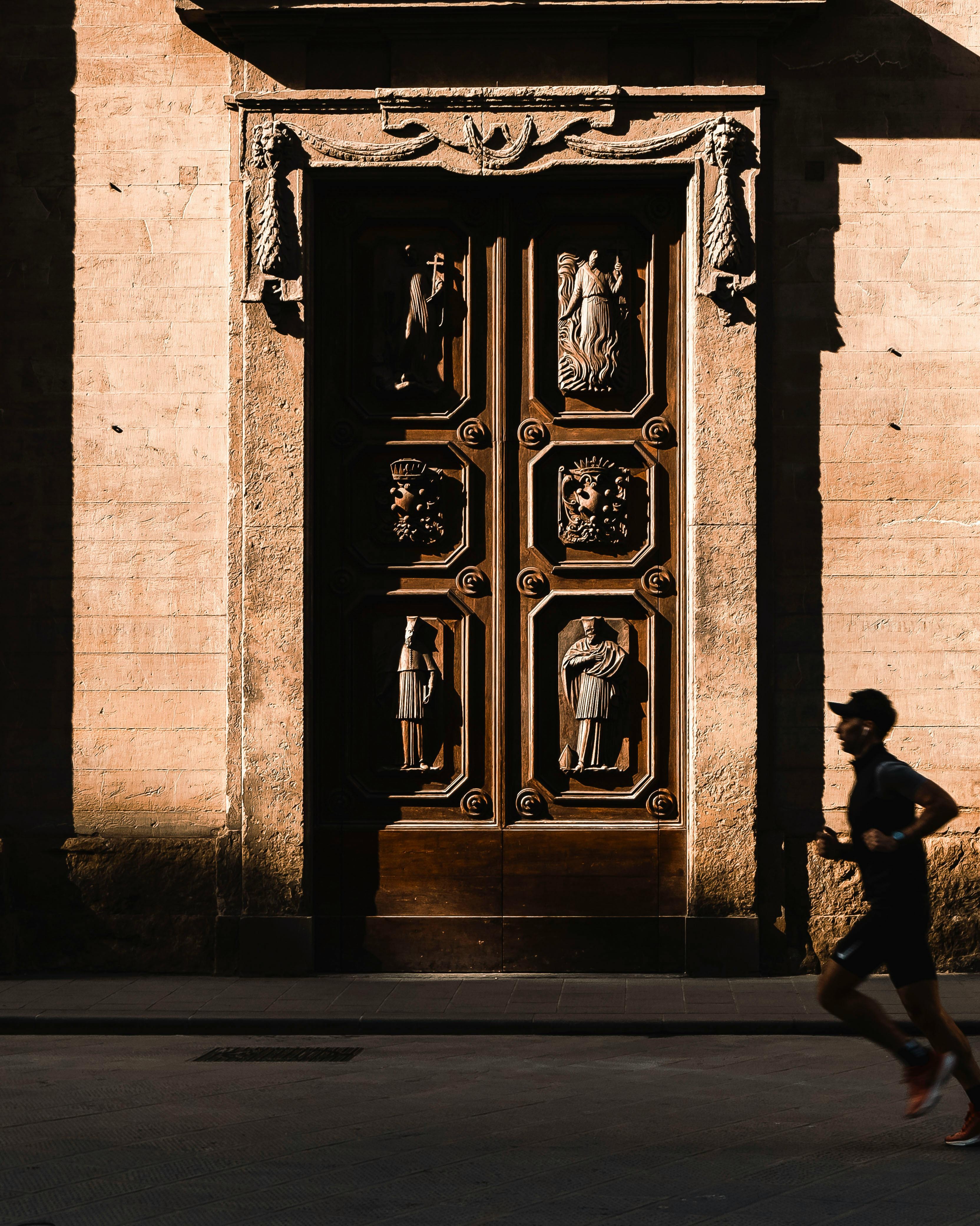 Jogger Runs Past Historic Carved Door