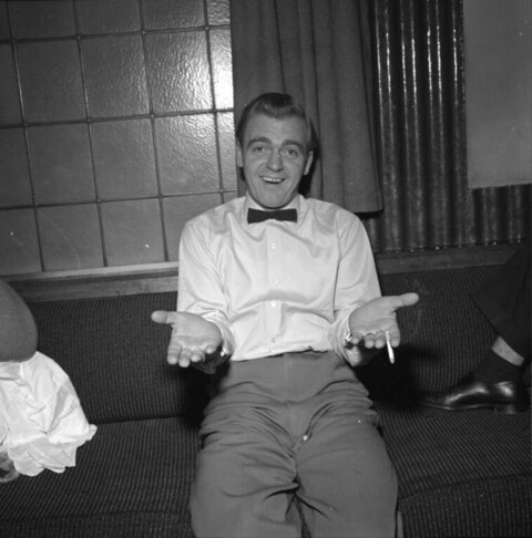 Smiling Man Gesturing While Sitting on Sofa
