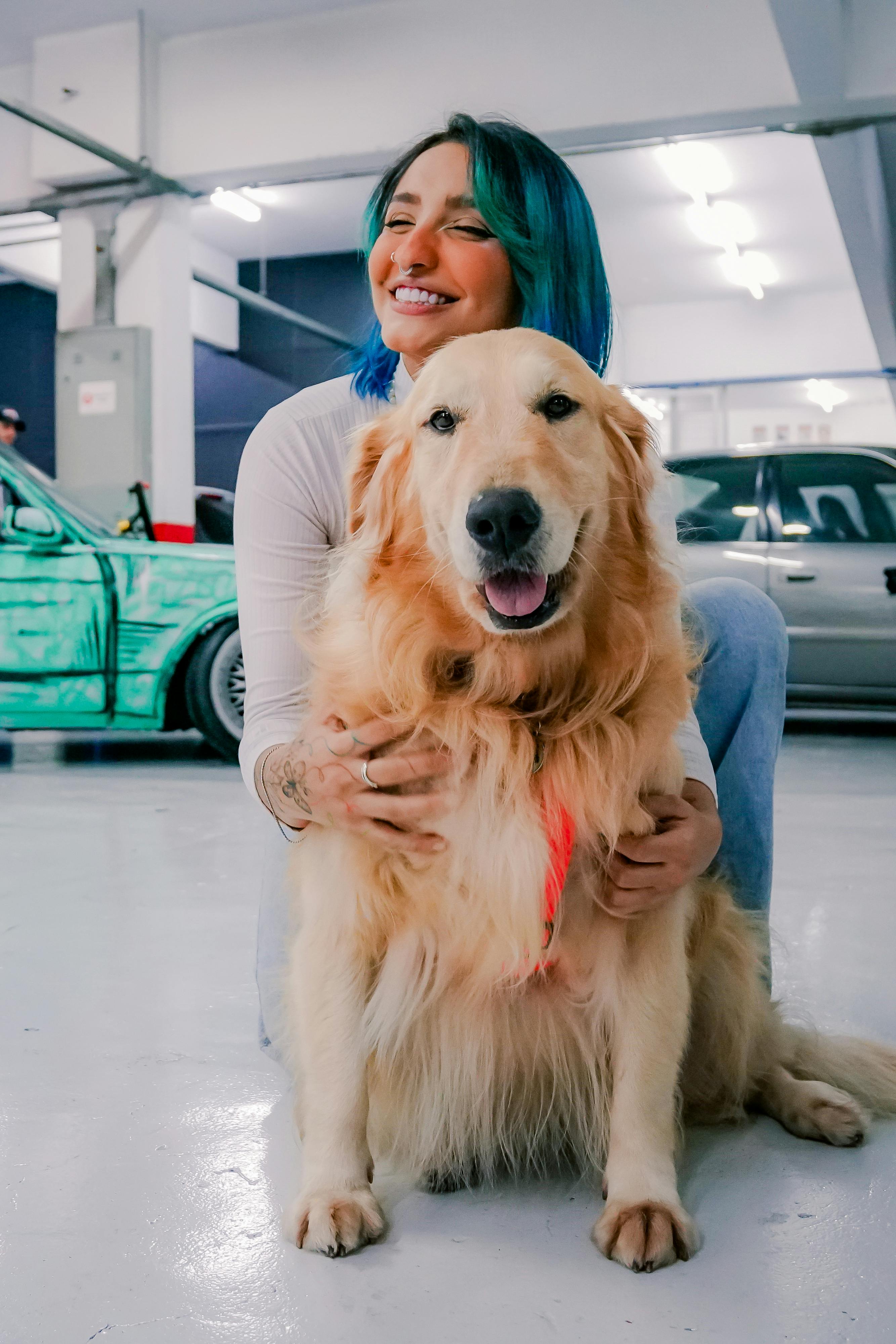Woman Hugging Golden Retriever In Garage