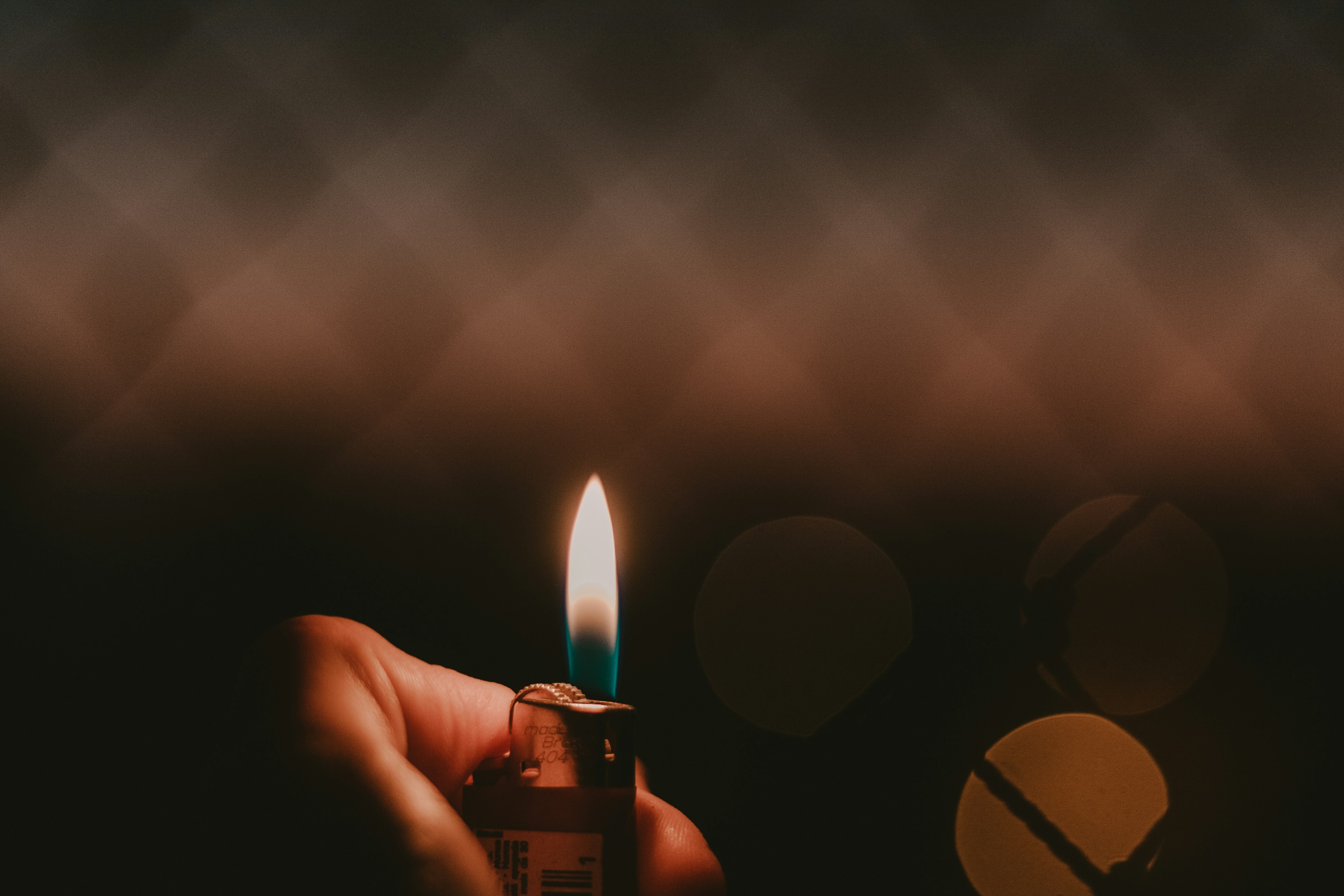 Hand Holding Lit Lighter in Dark