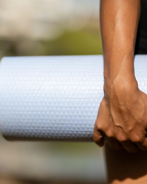 Hand Holding Light Blue Foam Roller