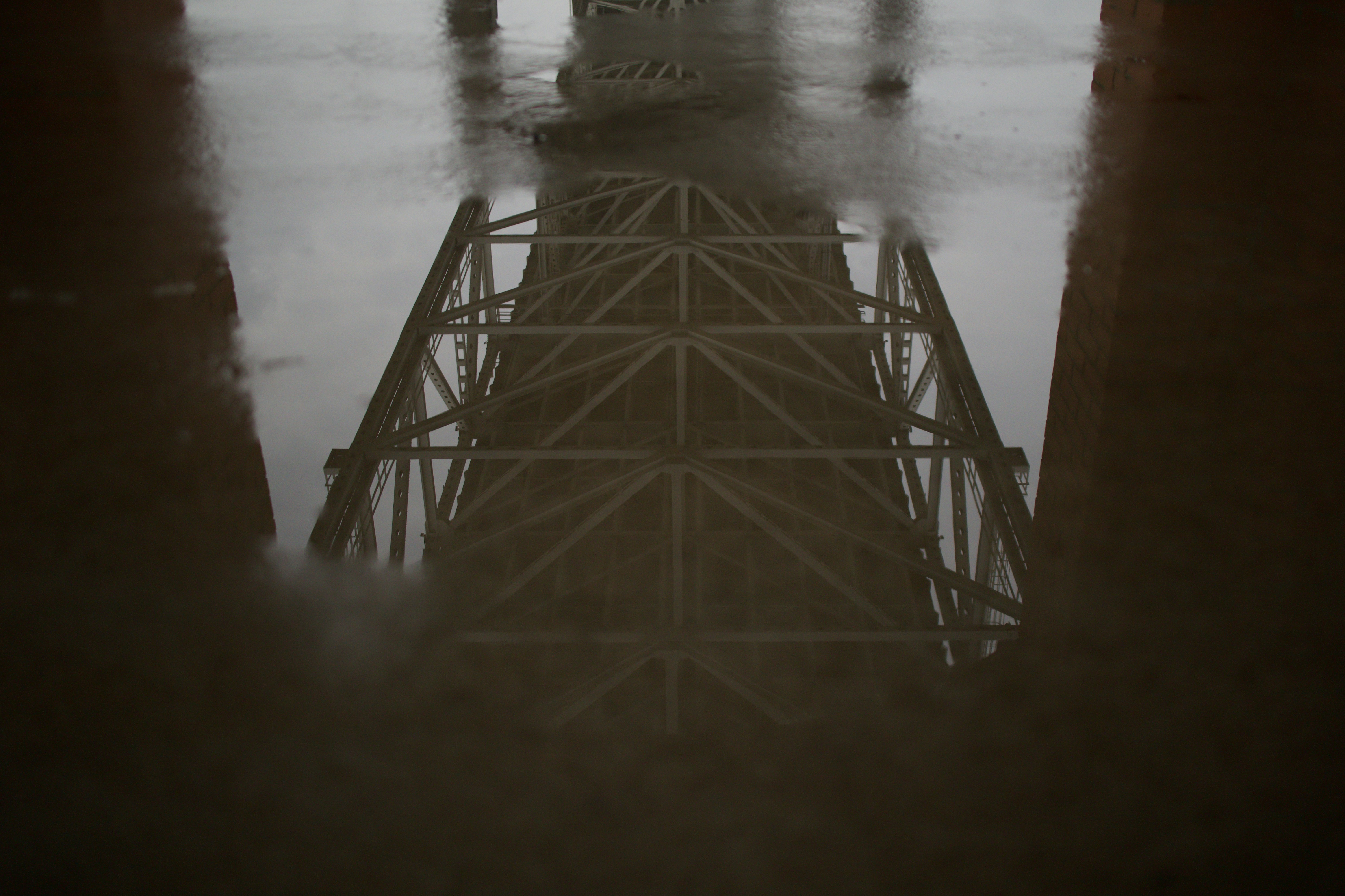 Reflection of Steel Bridge Tower in Puddle