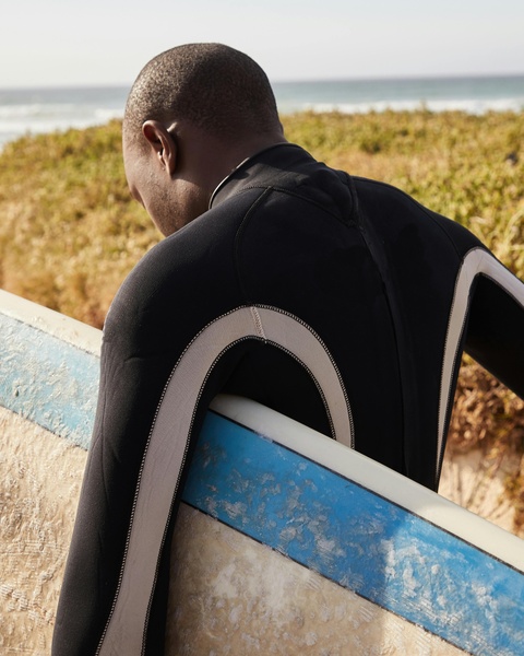 Surfer Carrying Surfboard at Beach