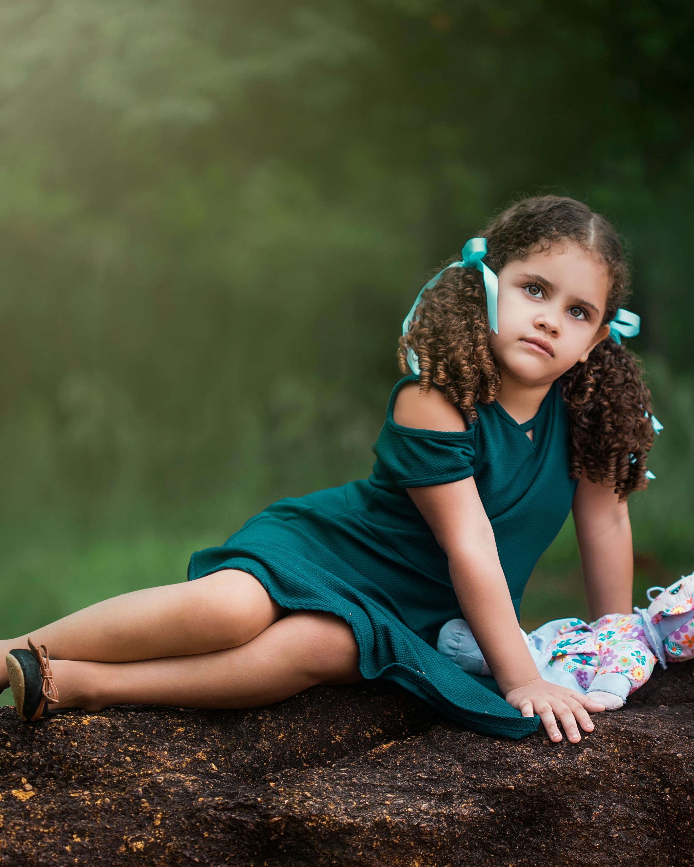 Little Girl Posing With Doll Outdoors